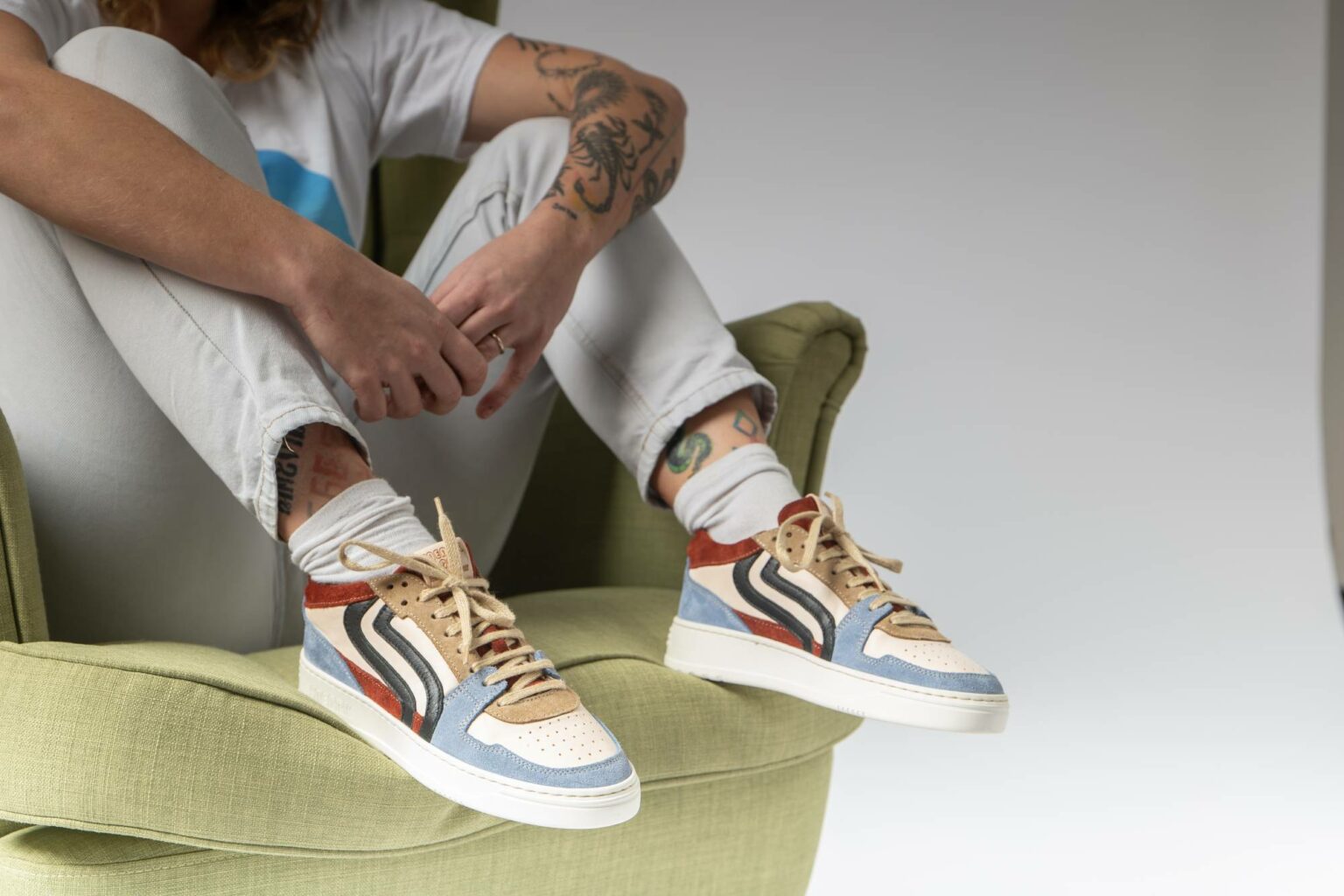 Ragazzo con sneaker Sneark su poltrona verde